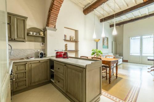 una cucina con armadi in legno e un tavolo in una stanza di 2 minuti dal Duomo - Parcheggio free a 3 minuti ad Arezzo