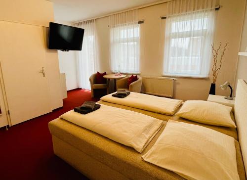 a hotel room with two beds and a flat screen tv at Pension Garni No.11 in Dresden