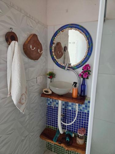 Un baño con un lavabo y un espejo en la pared. en Flat Lagoa Azul, en Maragogi