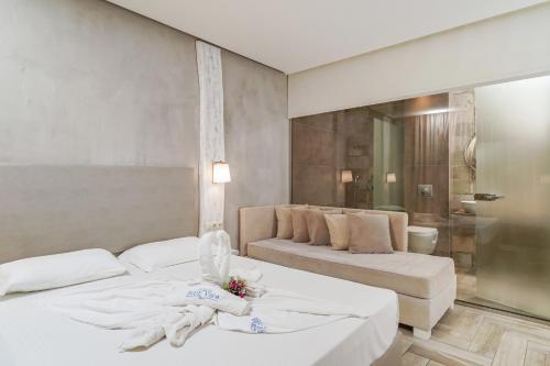 a hotel room with two beds and a couch at Blue view seaside hotel in Limenaria