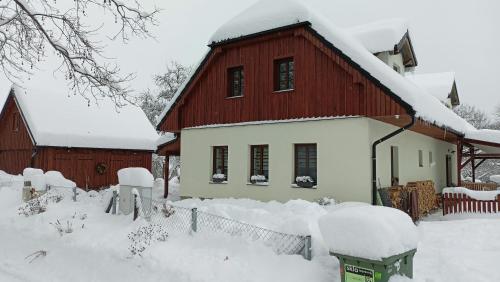 ein Haus mit Schnee auf dem Dach in der Unterkunft Penzion pod Čeřinkem in Mirošov