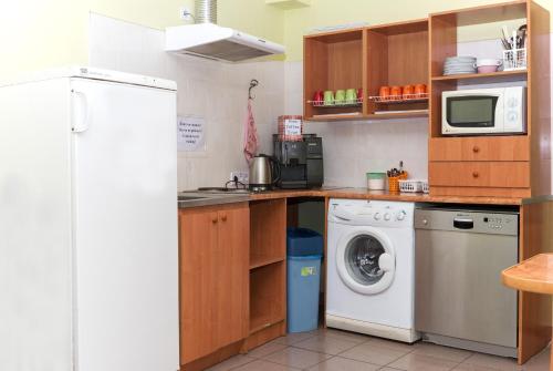 a kitchen with a refrigerator and a washing machine at Hotel 18 in Lviv