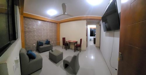 un salon avec une table, des chaises et une télévision dans l'établissement Hospedaje Luciana, à Pucallpa