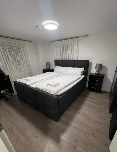 a bedroom with a large bed with white sheets at Wohnung in Metzingen