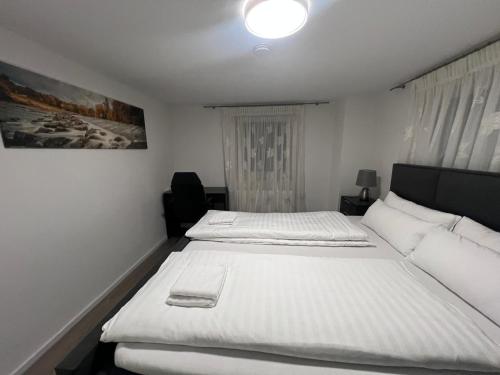 um quarto com uma cama grande com lençóis brancos em Wohnung em Metzingen