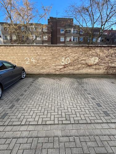Ein Auto, das neben einer Backsteinmauer geparkt ist, trägt darauf Zahlen. in der Unterkunft EasyPark City Suite in Braunschweig