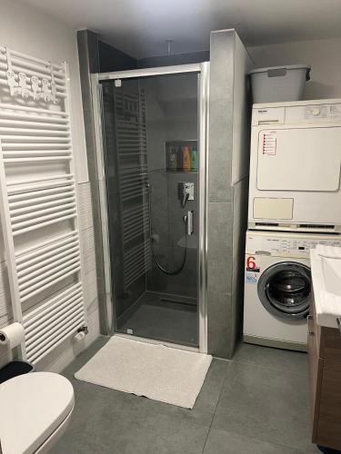a bathroom with a shower and a washing machine at Wohnung in Metzingen