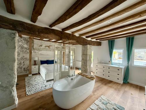 a large bathroom with a tub and a bedroom at La Maison du Port Sauvage - Au bord de la Loire in Saint-Clément-des-Levées