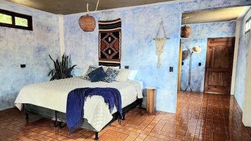 圣佩德罗拉拉古纳Views, Booze & Family Feuds! Chisme Not Included的蓝色房间里有一张床的卧室