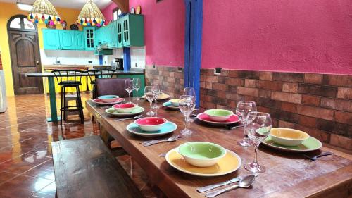 ein Holztisch mit Tellern und Weingläsern darauf in der Unterkunft Casa K in San Pedro La Laguna