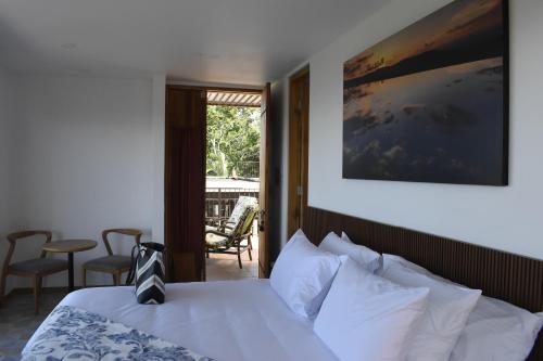 une chambre d'hôtel avec un lit et un balcon dans l'établissement Hotel Casa Portones, à San Bernardo