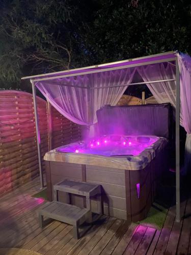a hot tub with purple lights and a bench at Détente sous le figuier in La Garde