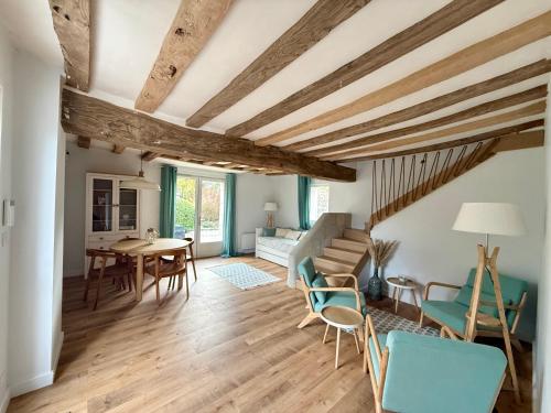 a living room with wooden ceilings and a table and chairs at La Maison du Port Sauvage - Au bord de la Loire in Saint-Clément-des-Levées
