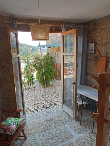 a door leading to a patio with a view of a yard at Quinta dos Campos - Apartamento 2 in Braga
