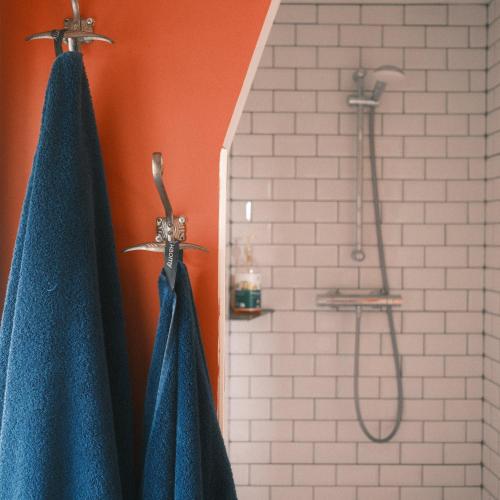 two blue towels are hanging in a bathroom at Chez Guilem chambre rose in Saint-Maixent-lʼÉcole