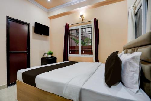 Un dormitorio con una cama grande y una ventana. en Hotel O kumar inn, en Lok Nayak Jayaprakash Airport