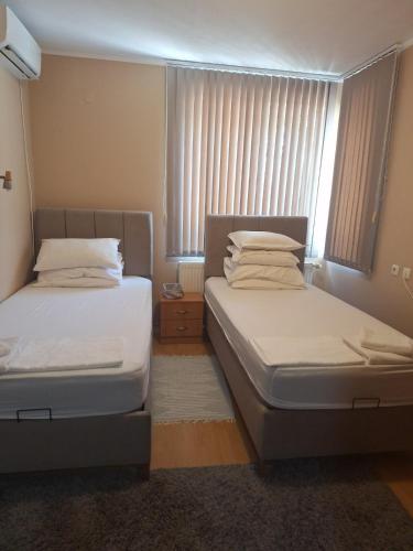 two beds in a small room with a window at Villa Irina in Kŭrdzhali