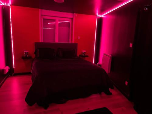 a bedroom with a bed with pink lights on it at CY L'unique instant in Wingles