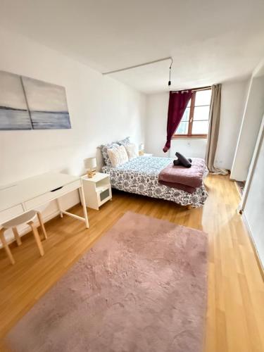 a bedroom with a bed and a desk and a rug at Charme cœur Obernai idéal marché de Noel in Obernai