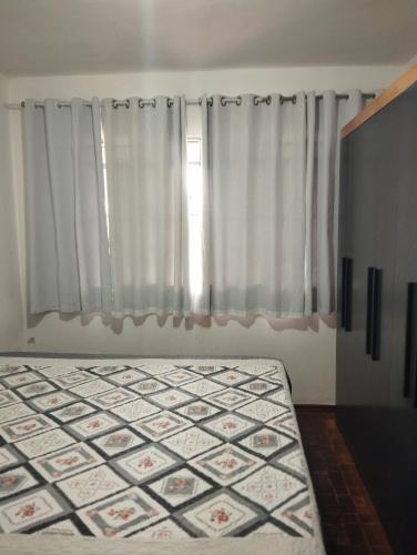 马林加Casa doce Lar的一间卧室，床位于窗前