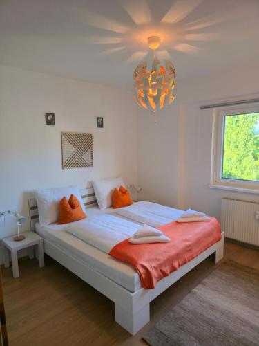 StainachにあるFerienwohnung Walcherのベッドルーム1室(オレンジの枕とシャンデリア付きのベッド1台付)