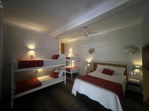 een slaapkamer met twee stapelbedden en twee bedkleppen bij Recanto Guaraú 4 in Peruíbe