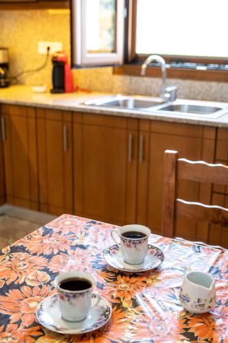 two cups of coffee on a table in a kitchen at Serenity House - Magic sunsets in Asfendioú