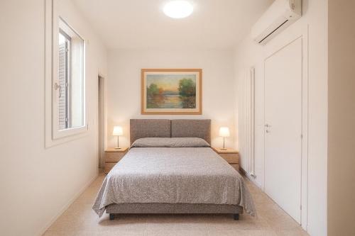 博洛尼亚Malvasia Asinelli Tower View - Residenza Oberdan, Bologna Centre的一间卧室，有一张床和两盏放在桌子上的灯