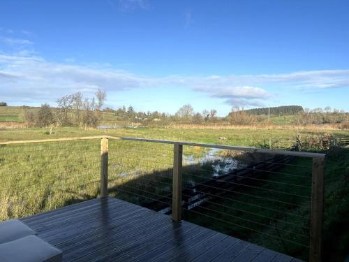 a deck with a view of a field at Waterside Studio Sanctuary in Belturbet
