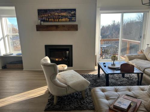 una sala de estar con un sofá y una chimenea en Deluxe Loft - Amazing Terrace with Stunning Water View, en Perth