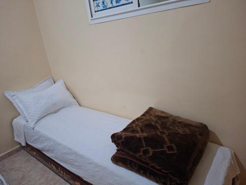 uma pequena cama com um cobertor castanho em cima em Stay in Rabat with local em Rabat