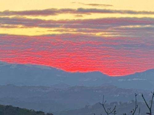 a sunset over the ocean with red clouds at La Fabbryca in Porto SantʼElpidio