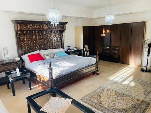 ein Schlafzimmer mit einem großen Bett mit einem hölzernen Kopfteil in der Unterkunft Furnished Villa in Andalusian Compound for Rent in Madaba