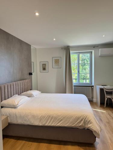a bedroom with a large bed and a window at Villa du Parc de Scey in Dole