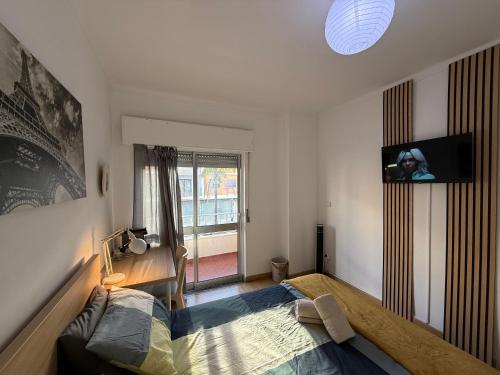 Entroncamento & Fátima في انترونكامنتو: غرفة نوم بسرير وتلفزيون على الحائط