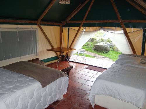 a room with two beds in a tent at Glamping El Establo in San Francisco