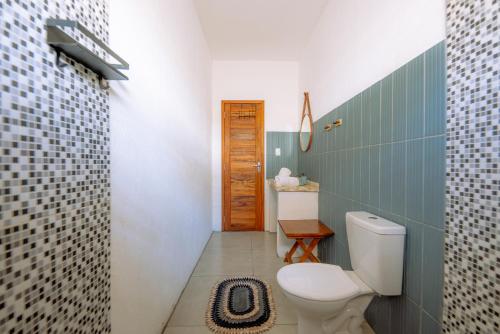 ein Bad mit einem WC und einer Fliesenwand in der Unterkunft Casa Iguana in Trairi