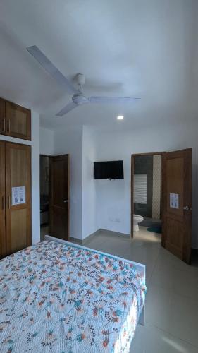une chambre avec un lit et un ventilateur de plafond dans l'établissement Mitaly apartamentos RD H, à Saint-Domingue