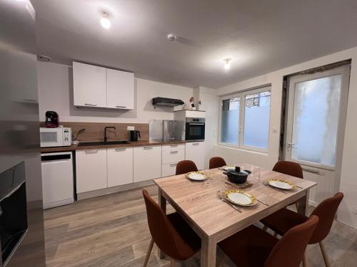 eine Küche mit einem Holztisch und Stühlen in einem Zimmer in der Unterkunft Maison Moderna-8 personnes-WiFi-Centre ville in Fontenay-le-Comte