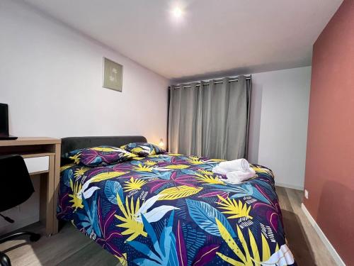 ein Schlafzimmer mit einem Bett mit einer bunten Decke in der Unterkunft Maison Moderna-8 personnes-WiFi-Centre ville in Fontenay-le-Comte