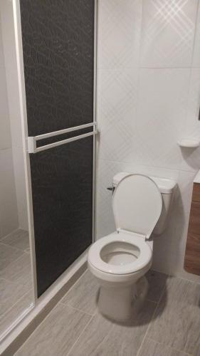 a bathroom with a toilet and a shower stall at Cabaña alma del bosque in San Gil