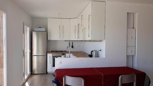 une cuisine avec des armoires blanches et un réfrigérateur dans l'établissement Maison bois proche de l' A6, à Brianny