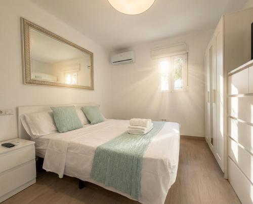 ein weißes Schlafzimmer mit einem Bett und einem Spiegel in der Unterkunft 3 Double Beds - Great Area, Perfect for Families in Sevilla