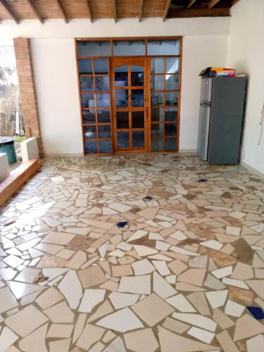a room with a stone floor and a refrigerator at Hostal Brisa y Mar in Arboletes