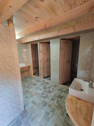 a large bathroom with a sink and a counter at Sustainable Samel's Cottage Hrid's lake Prokletije in Plav