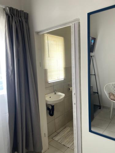 a bathroom with a sink and a mirror at Lani Accommodation in Pretoria