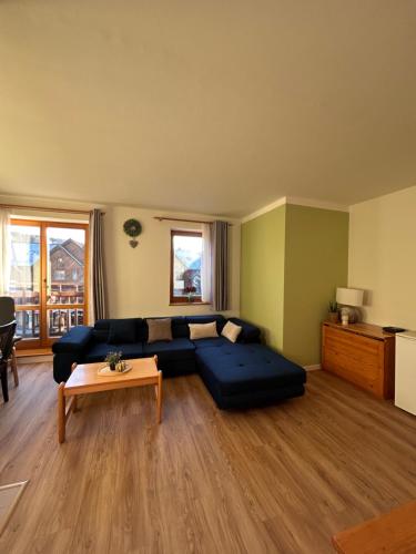 RokytnoにあるApartmán pod sjezdovkou Lysá Hora Horní náměstí Ski Lumiの青いソファとテーブルのあるリビングルーム