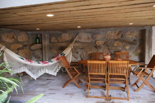 a patio with a hammock and a table and chairs at Quinta da Lage Agroturismo e Enoturismo in Celorico de Basto