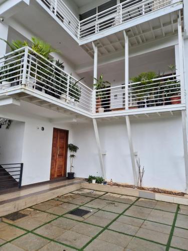 un edificio blanco con balcones y un patio en Willow The Villas, en Mananthavady
