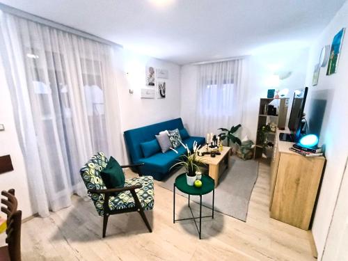 a living room with a blue couch and a table at Vikendica Mladenović in Divčibare